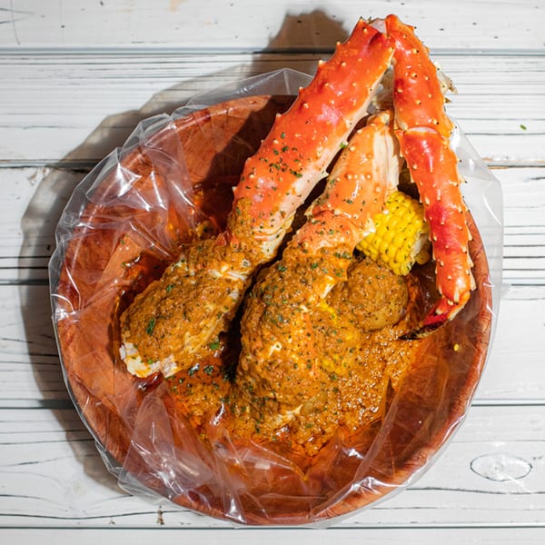 Ben's Crab seafood boil with king crab legs, corn, and potatoes in a spicy sauce.