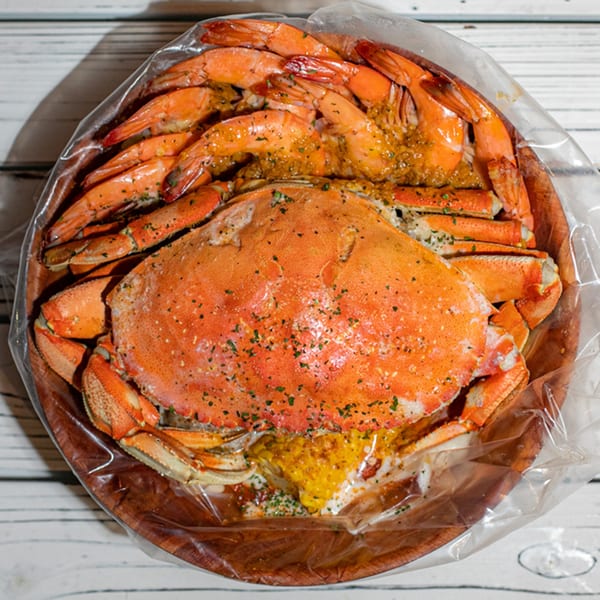 Ben's Crab seafood boil with a whole crab, shrimp, and corn in a bag.