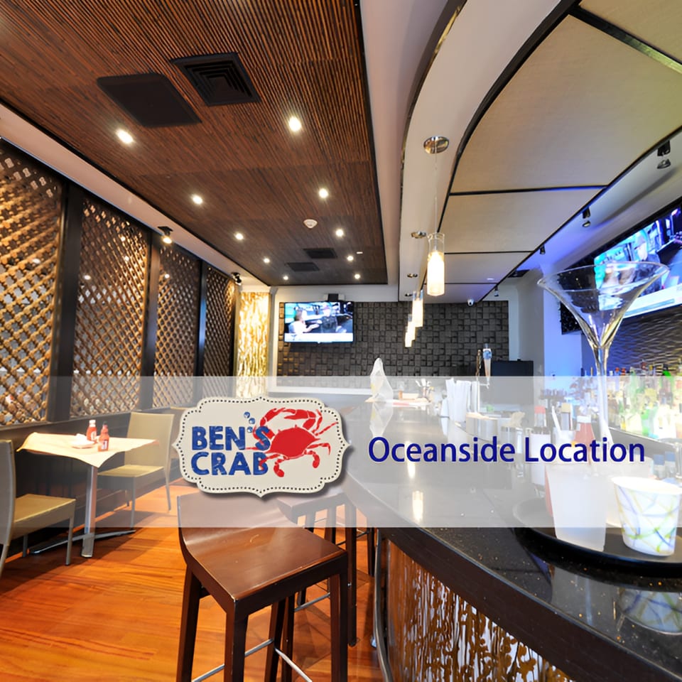 Interior of Ben's Crab Oceanside with a bar, dining tables, and a TV playing in the background.