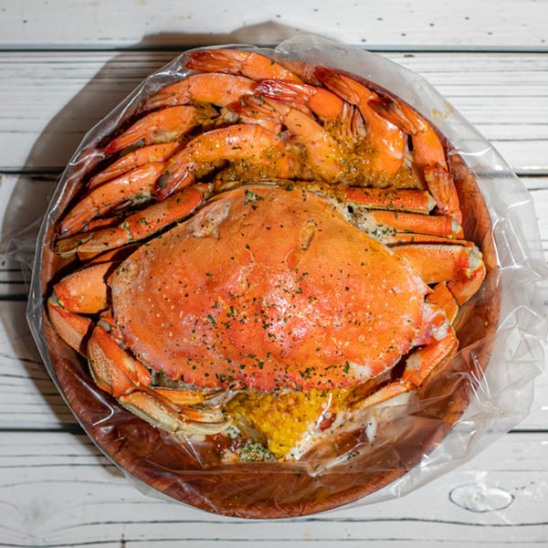 Ben's Crab seafood boil with a whole crab, shrimp, and corn in a clear bag.