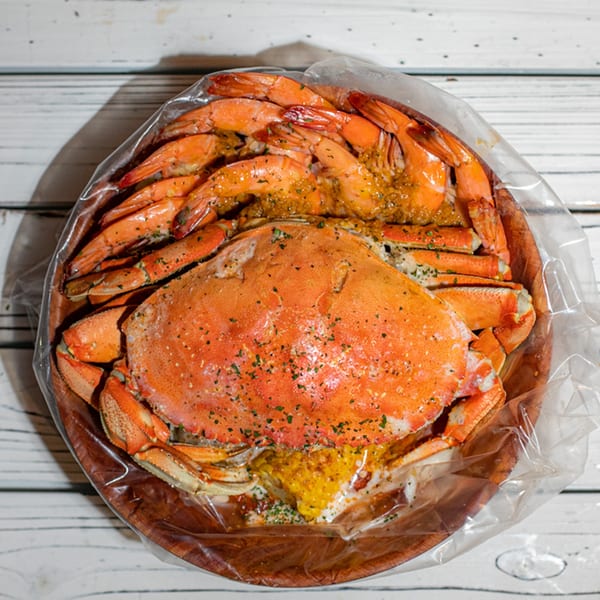A Ben's Crab seafood boil with a whole crab and shrimp in a plastic bag.